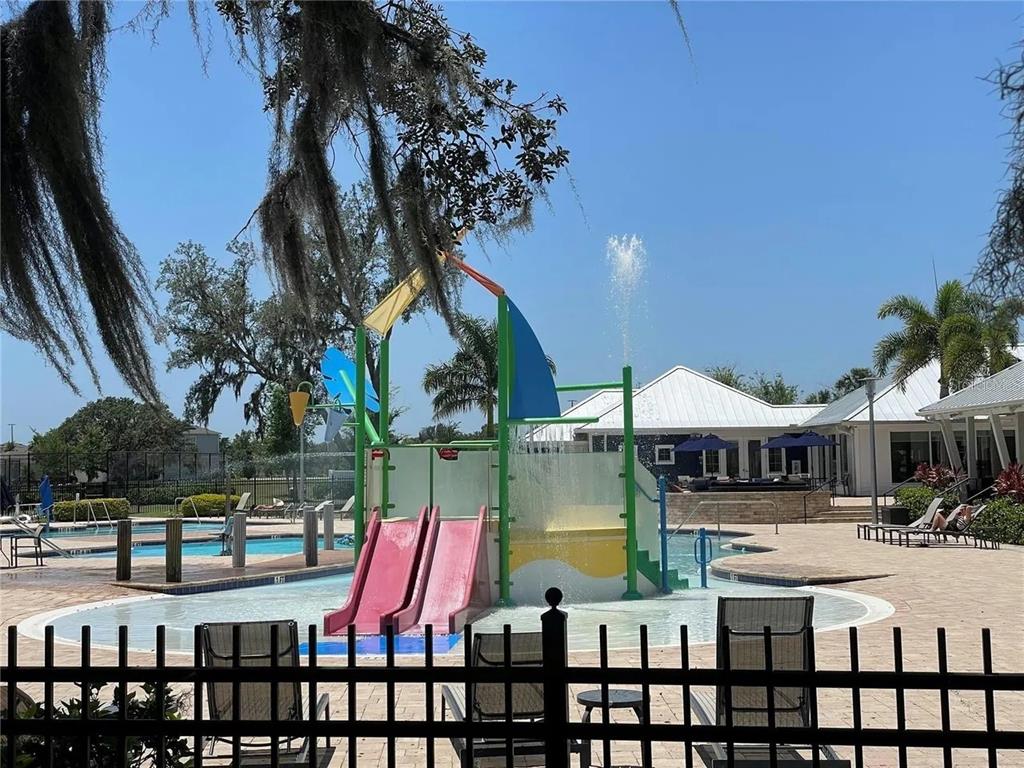 A community pool area features a colorful children's water play structure with slides and fountains — 13109 FRUITVILLE WAY, RIVERVIEW, FL