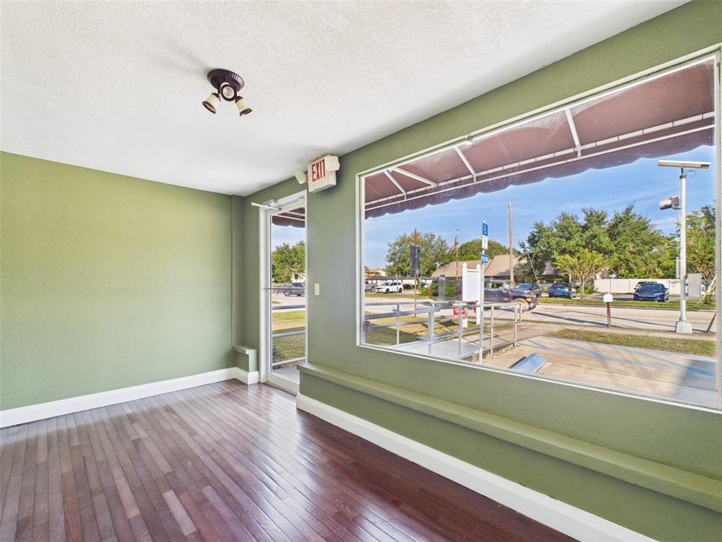 An interior room with dark wood floors, white walls, and two doorways — 318 S 1ST STREET, LAKE WALES, FL