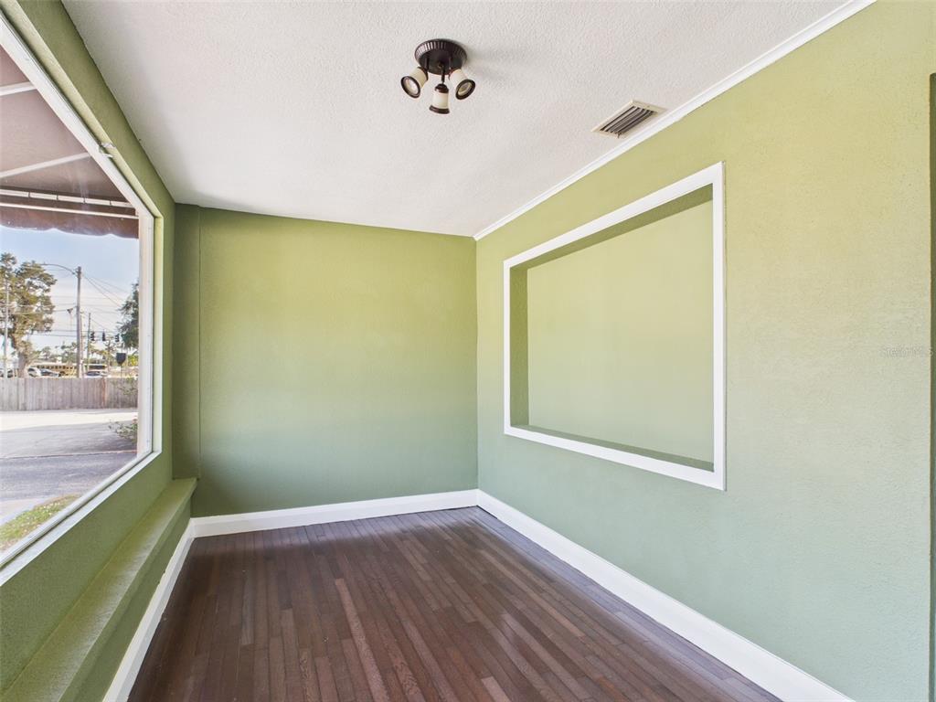 An empty room with dark wood floors, white walls, a window, and an exit sign — 318 S 1ST STREET, LAKE WALES, FL