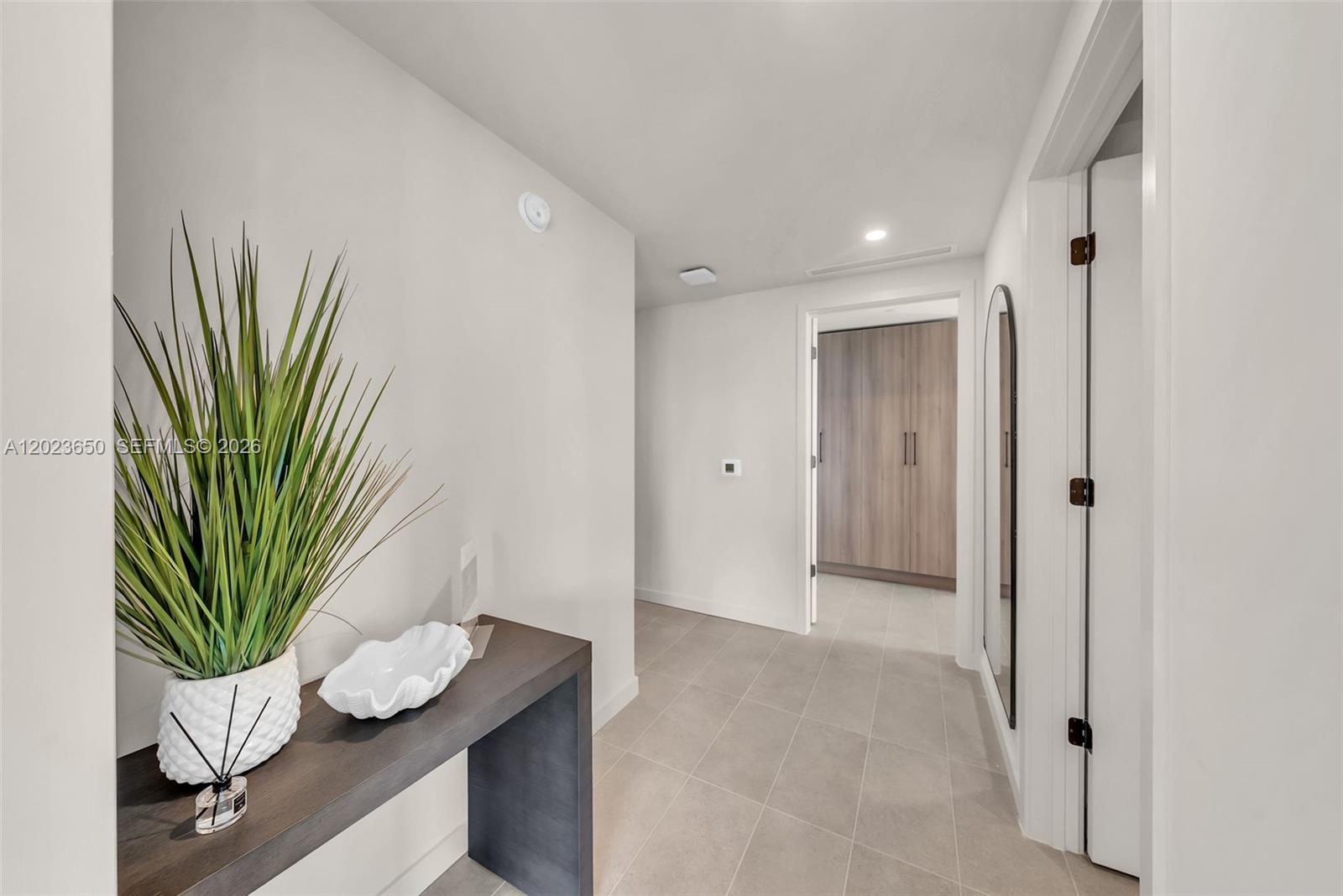 A hallway features a console table with a plant, tile flooring, and a doorway ahead — 121 NE 5th St # 3401, Miami FL 33132, MIAMI, FL