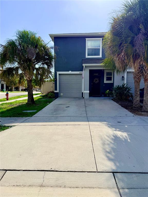 A two-story blue house features a single-car garage, a front entrance, and two palm trees — 3830 VIGNOBLE LANE, BRANDON, FL
