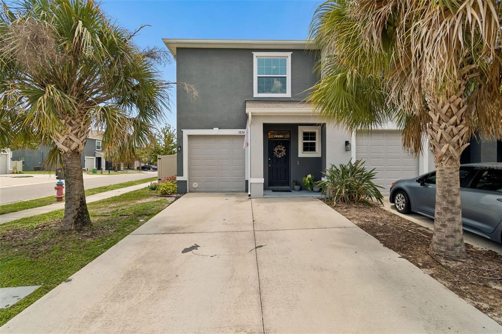 A two-story townhouse with a gray exterior, a single-car garage, and a concrete driveway — 3830 VIGNOBLE LANE, BRANDON, FL