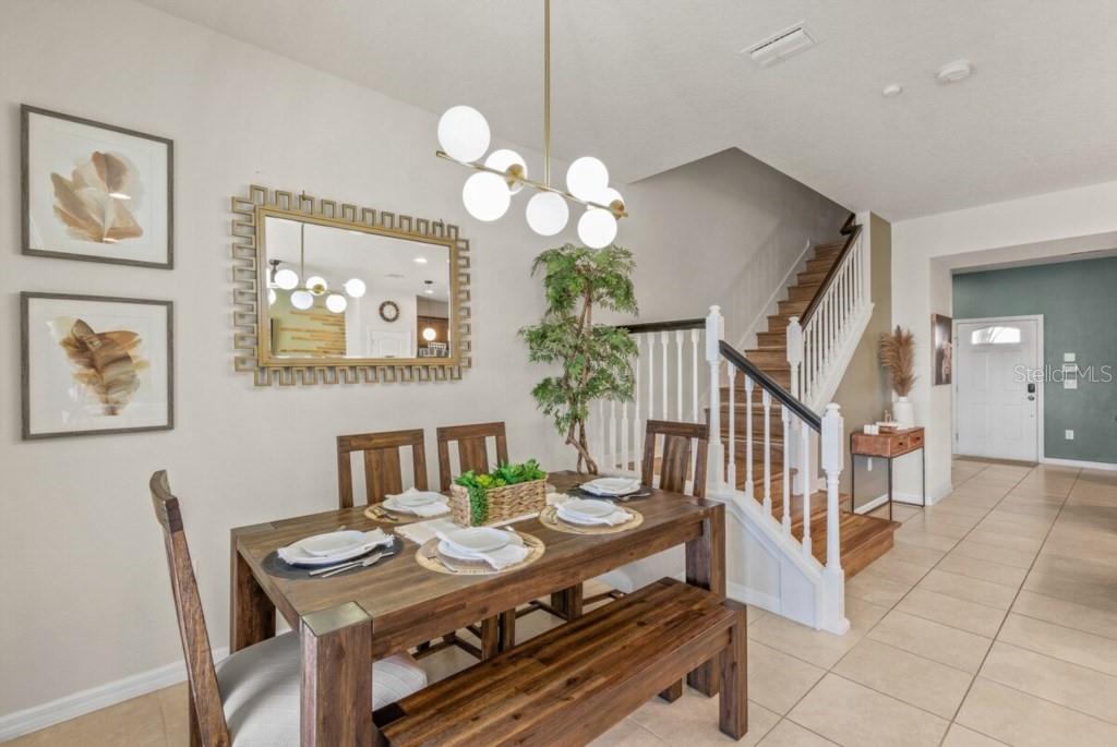 A kitchen features wood cabinets, granite countertops, a stainless steel refrigerator, and a breakfast island — 8838 GENEVE COURT, KISSIMMEE, FL
