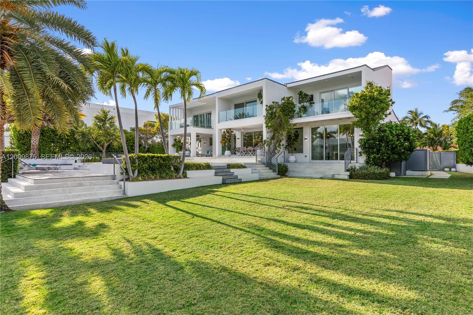 A modern two-story white house features a large lawn, palm trees, and glass balconies — 120 Knollwood Dr, Key Biscayne FL 33149, KEY BISCAYNE, FL