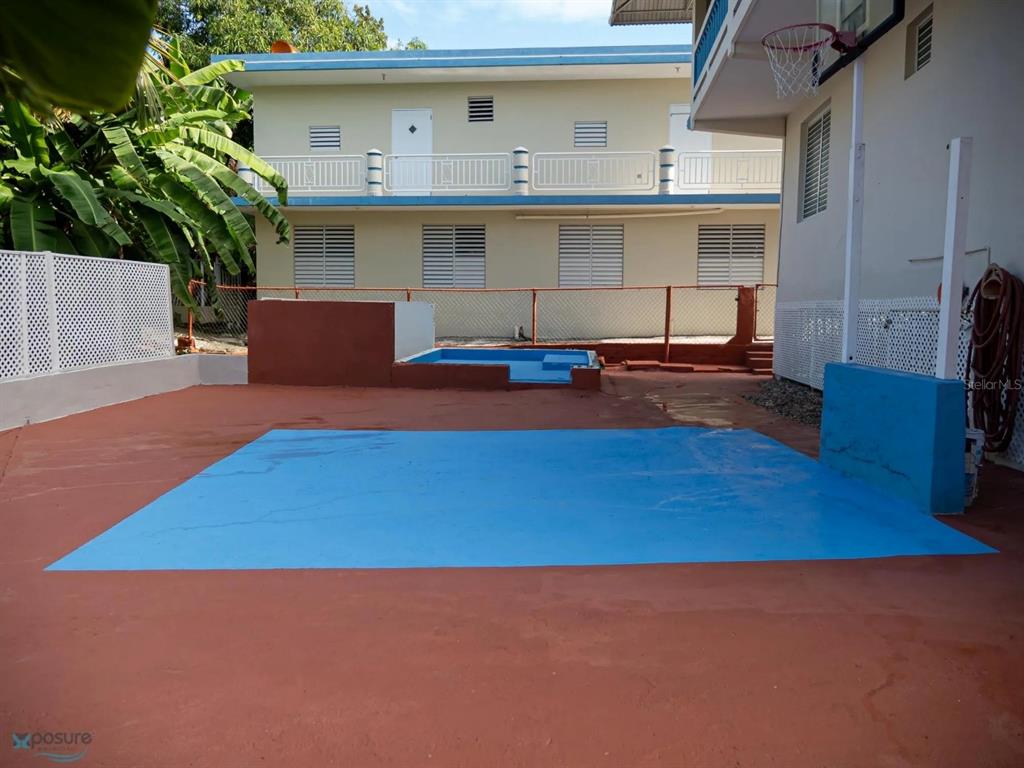 A paved outdoor area features a basketball hoop, a small pool, and a two-story building — 373 CALLE FRANCISCO COLON GUERRA BO PUEBLO, RINCON, PR