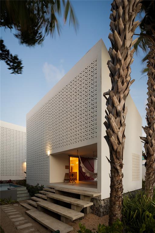A modern white house with a perforated facade and concrete steps leading to a patio — CASA BAJURA CALLE MONTE DE OCA #7, ISABELA, PR