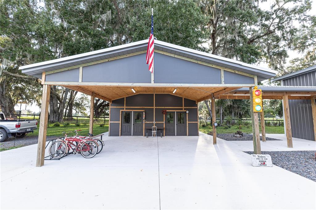 A covered concrete patio features double doors, a flag, and a traffic light decoration — 12523 CR 721, WEBSTER, FL