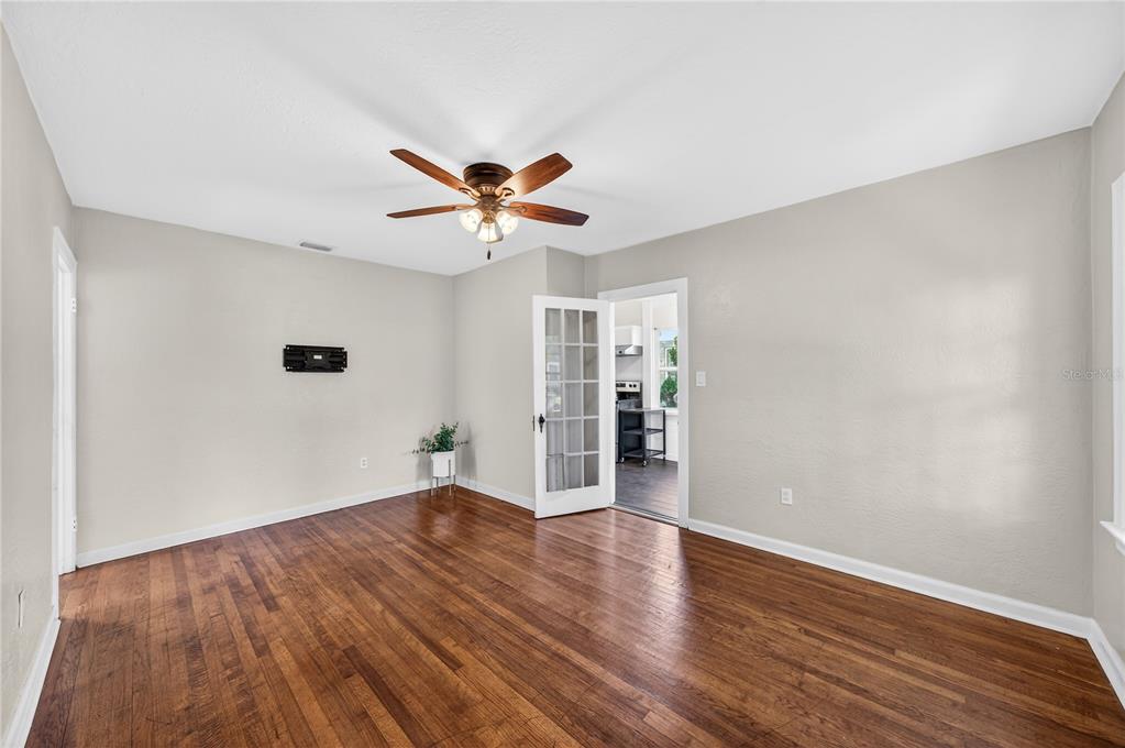 An empty room with hardwood floors, light gray walls, a ceiling fan, and French doors — 2006 CORNELL AVENUE, WINTER PARK, FL