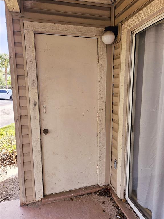 An exterior view shows a beige door and a sliding glass door on a patio — 1916 LAKE ATRIUMS CIRCLE UNIT 25, ORLANDO, FL