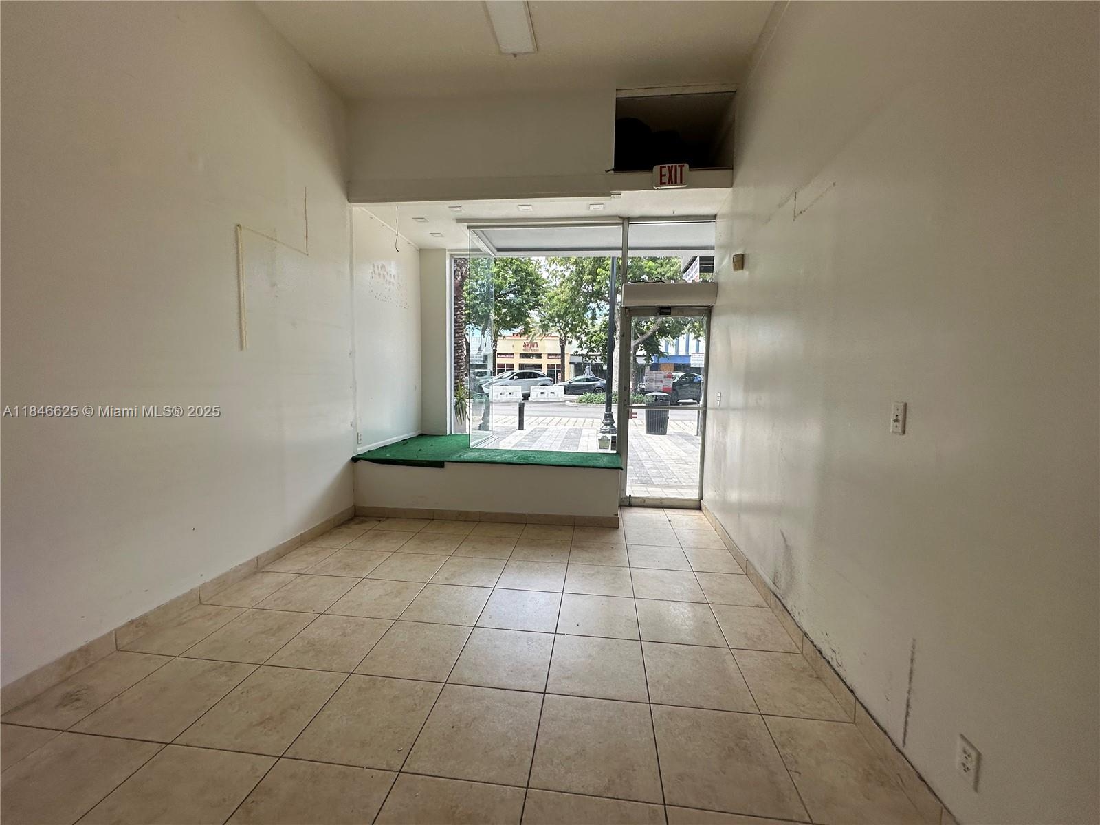 An empty commercial space features beige tile flooring, white walls, and a large front window — 1932 Hollywood Blvd, Hollywood FL 33020, HOLLYWOOD, FL