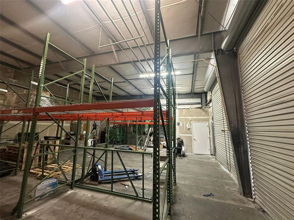 An industrial warehouse space features tall metal storage racking and a concrete floor — 1630 TROPIC PARK DRIVE UNIT 1630, SANFORD, FL