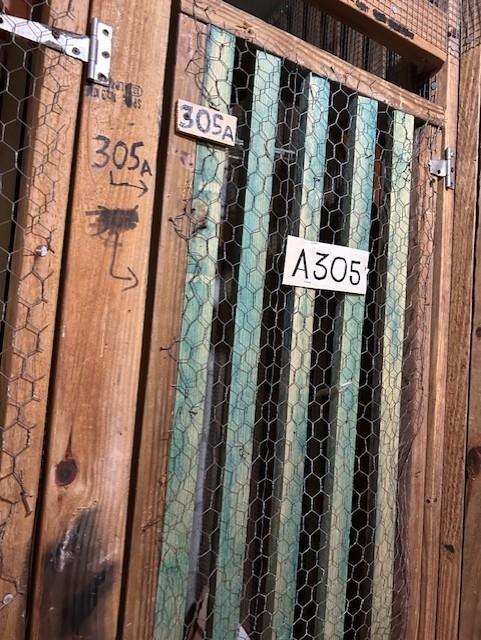 A wooden storage unit door features chicken wire mesh and multiple labels reading 305A and A305 — 3590 Blue Lake Drive # 305, Pompano Beach FL 33064, POMPANO BEACH, FL