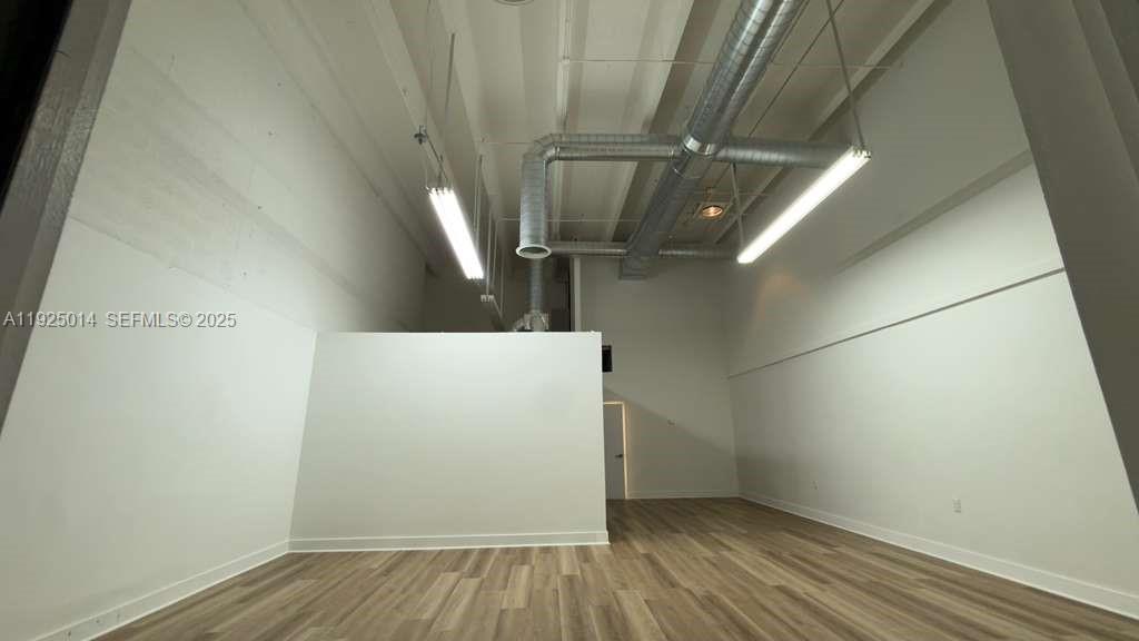 An interior view of a commercial space with high ceilings, exposed ductwork, and wood-look flooring — 1671 W 37th St # 1, Hialeah FL 33012, HIALEAH, FL