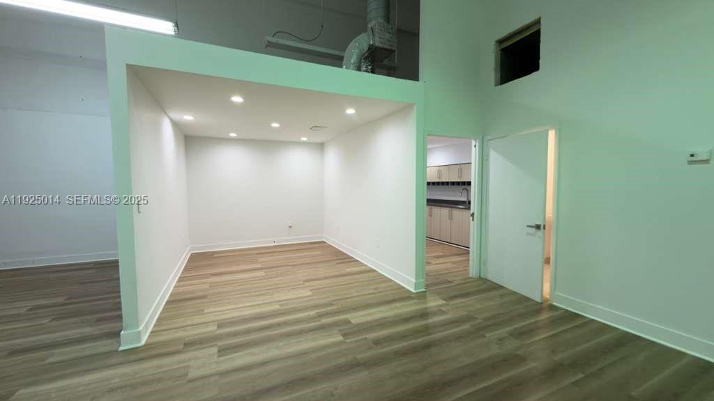 An interior view shows a room with light wood-look flooring, recessed lighting, and a doorway — 1671 W 37th St # 1, Hialeah FL 33012, HIALEAH, FL