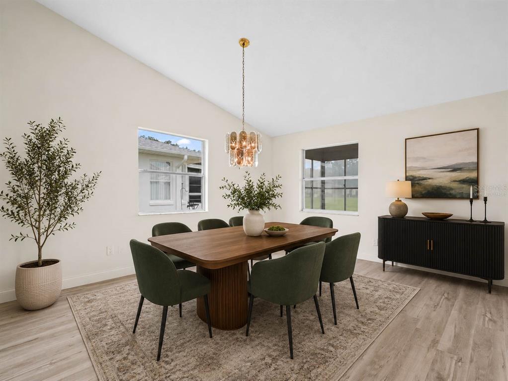 A dining room featuring a wooden table, green chairs, a chandelier, and a black sideboard — 6341 SILVER LAKES DRIVE W, LAKELAND, FL