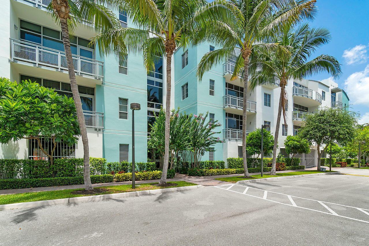 A multi-story apartment building with light blue walls, balconies, and palm trees in front — 335 SE 6th Avenue # 304, Delray Beach FL 33483, DELRAY BEACH, FL
