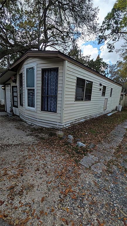 The exterior of a light-colored mobile home features horizontal siding and several windows — 3000 CLARCONA ROAD UNIT 520, APOPKA, FL