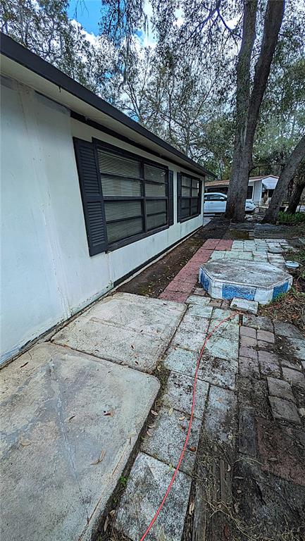 An exterior view shows a white house with dark shutters and a paved patio area — 3000 CLARCONA ROAD UNIT 520, APOPKA, FL