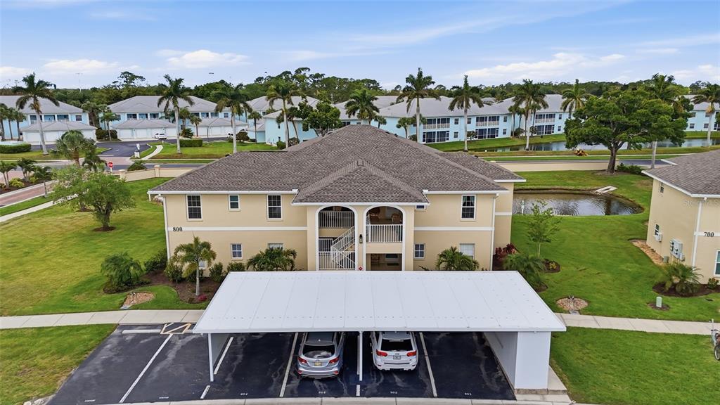 An aerial view shows a two-story apartment building with a covered carport in front — 5800 SABAL TRACE DRIVE UNIT 801, NORTH PORT, FL
