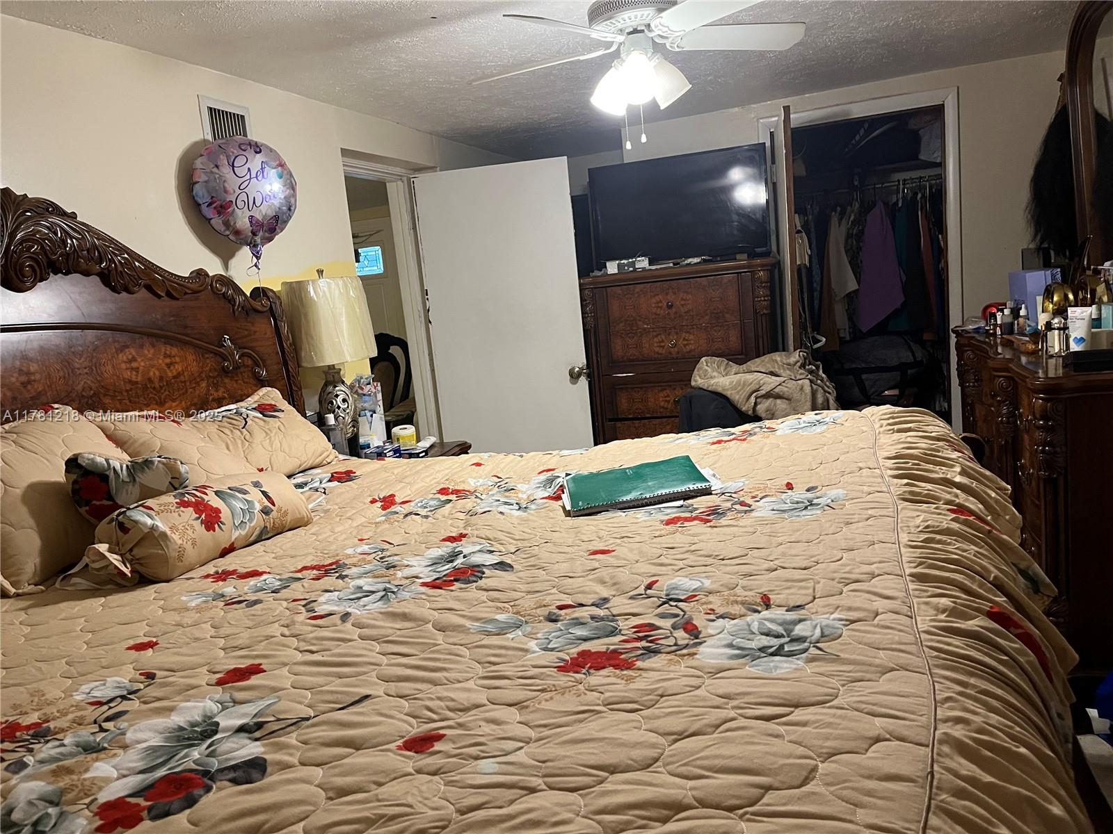 A bedroom features a large wooden bed, floral bedding, a ceiling fan, and a closet — 6546 SW 20th Ct, Miramar FL 33023, MIRAMAR, FL