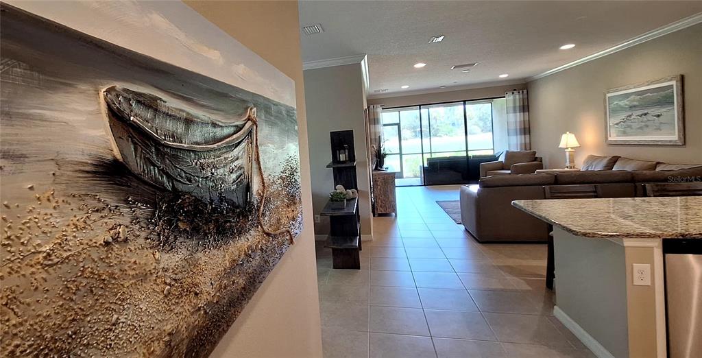 A view from a kitchen island looking toward a living room with a large painting — 12740 SORRENTO WAY UNIT 101, BRADENTON, FL