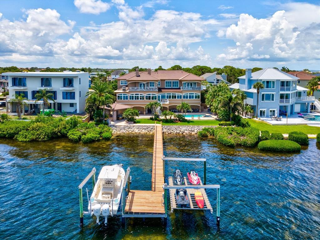 An aerial view of a waterfront house with a long wooden dock and boat lift — 2057 N POINTE ALEXIS DRIVE, TARPON SPRINGS, FL