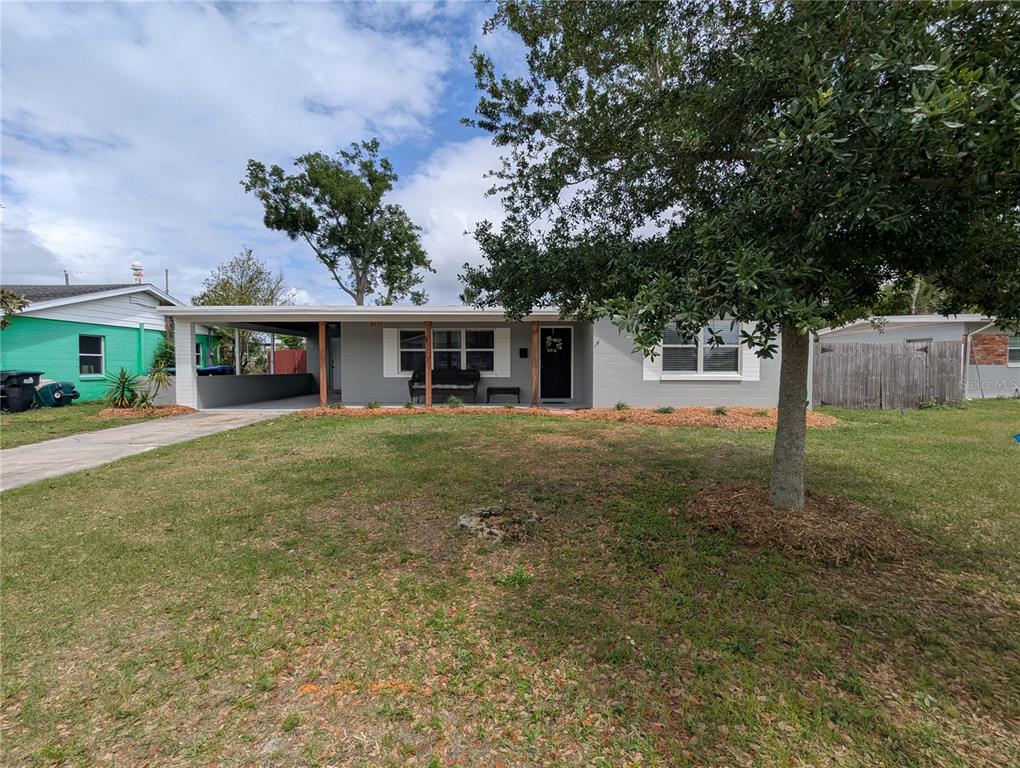 A single-story gray house with a front porch and carport sits on a grassy lot — 5421 ALLOWAY STREET, ORLANDO, FL