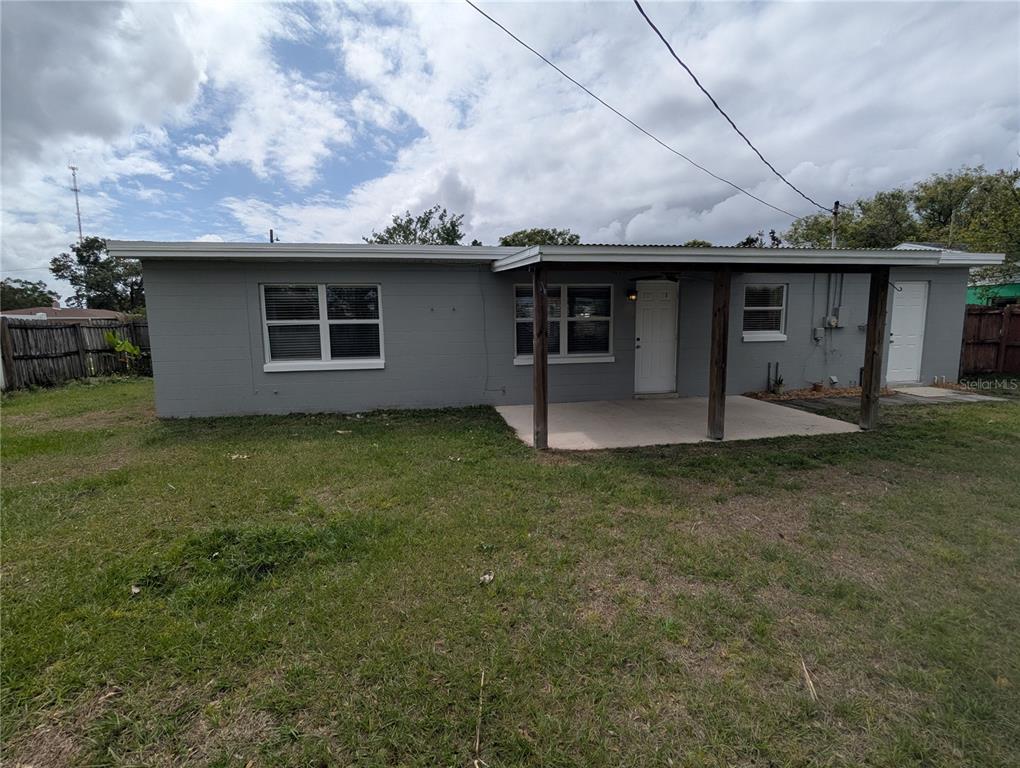 A gray, single-story house with a covered concrete patio and a fenced backyard — 5421 ALLOWAY STREET, ORLANDO, FL