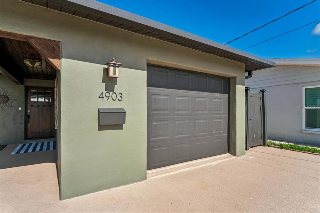 An exterior view of a house featuring a garage, a front door, and a mailbox — 4903 BLUE HERON DRIVE, NEW PORT RICHEY, FL