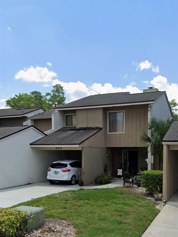 A two-story townhouse with a carport, a white SUV, and a small front lawn — 484 PRESTWICK PLACE, KISSIMMEE, FL