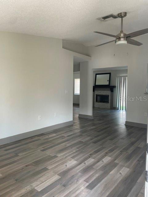 An interior view shows a living area with gray wood-look flooring and a ceiling fan — 1100 LOWRY AVENUE UNIT 33, LAKELAND, FL