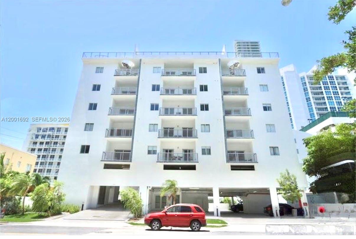 A white multi-story apartment building with balconies and a ground-level parking area — 481 NE 29th St # 502, Miami FL 33137, MIAMI, FL