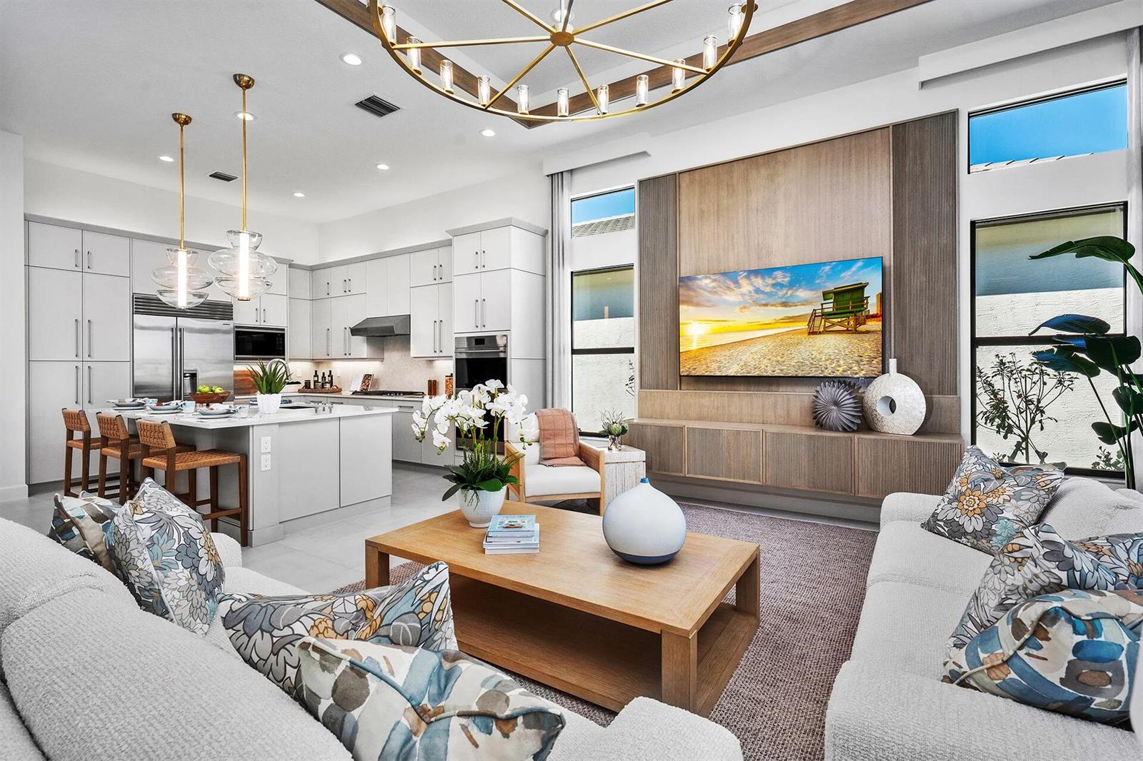 A modern open-concept living room and kitchen featuring light cabinetry, wood accents, and a chandelier — 9124 Red Robin Lane, Boynton Beach FL 33473, BOYNTON BEACH, FL