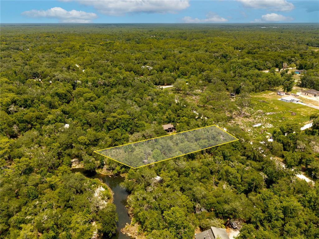 An aerial view shows a rectangular plot of land outlined in yellow near a river — 7337 RIVERVIEW DRIVE, WEBSTER, FL