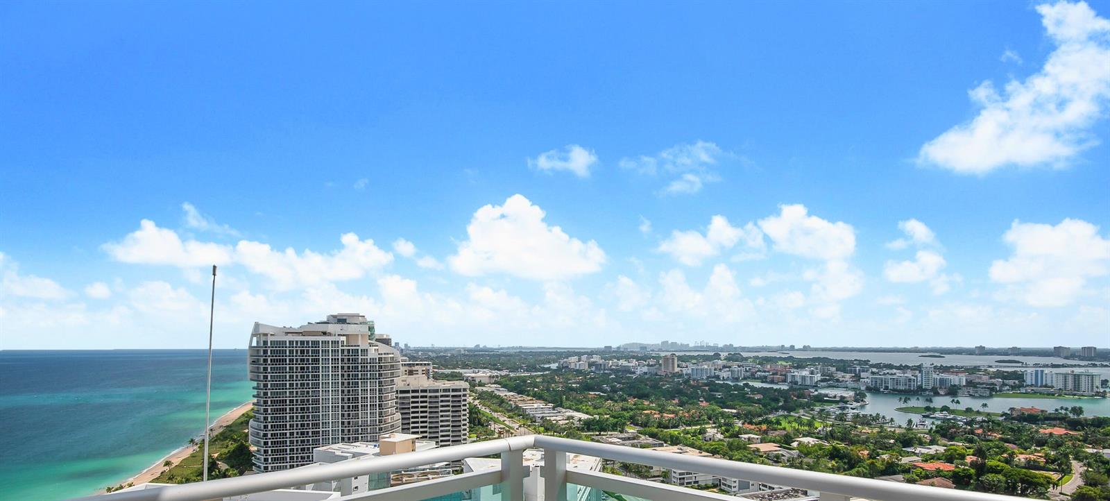 A high-angle view from a balcony overlooking the ocean, coastline, and city skyline — 10295 Collins Avenue # 2203, Bal Harbour FL 33154, BAL HARBOUR, FL