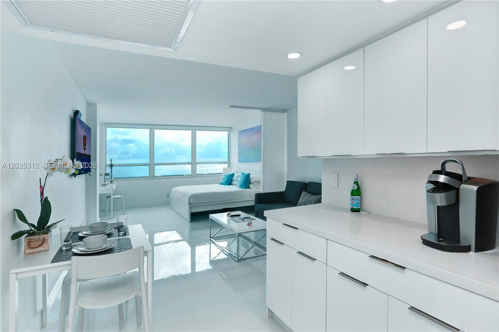 A bright studio apartment features a white kitchen, dining area, and bedroom with ocean views — 5445 Collins Ave # 1232, Miami Beach FL 33140, MIAMI BEACH, FL