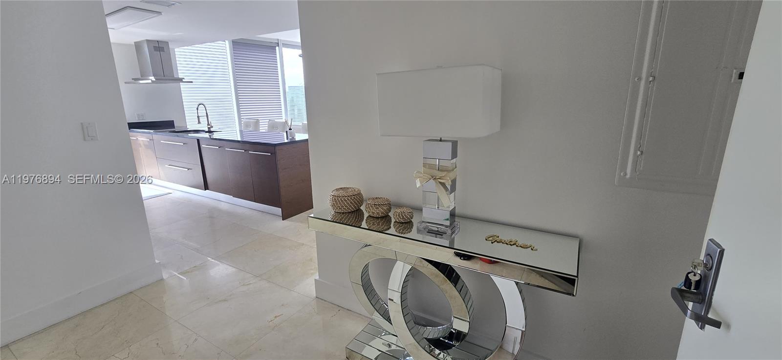 A mirrored console table with a lamp sits in a foyer near a kitchen — 495 Brickell Ave # 5310, Miami FL 33131, MIAMI, FL
