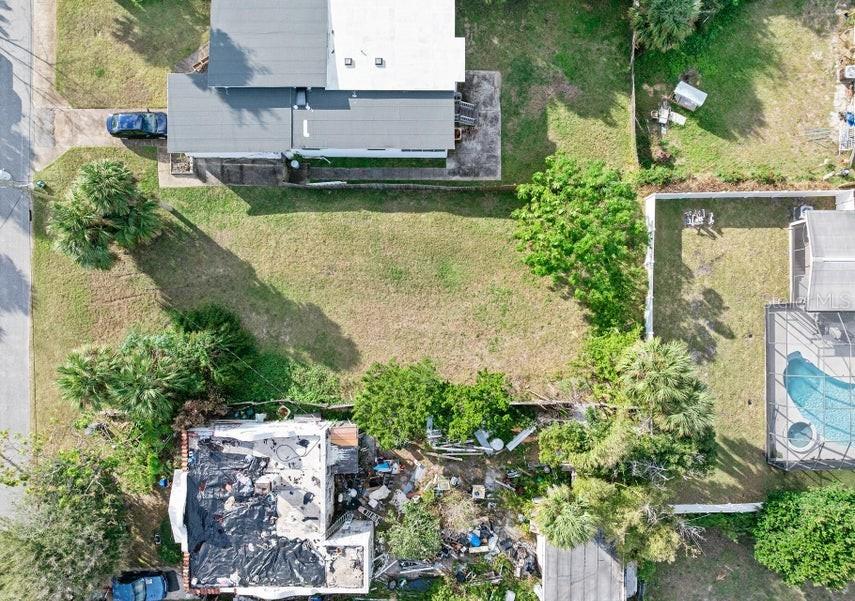 An aerial view shows a vacant rectangular lot situated between two residential properties — 339 MANHATTAN AVENUE, DAYTONA BEACH, FL