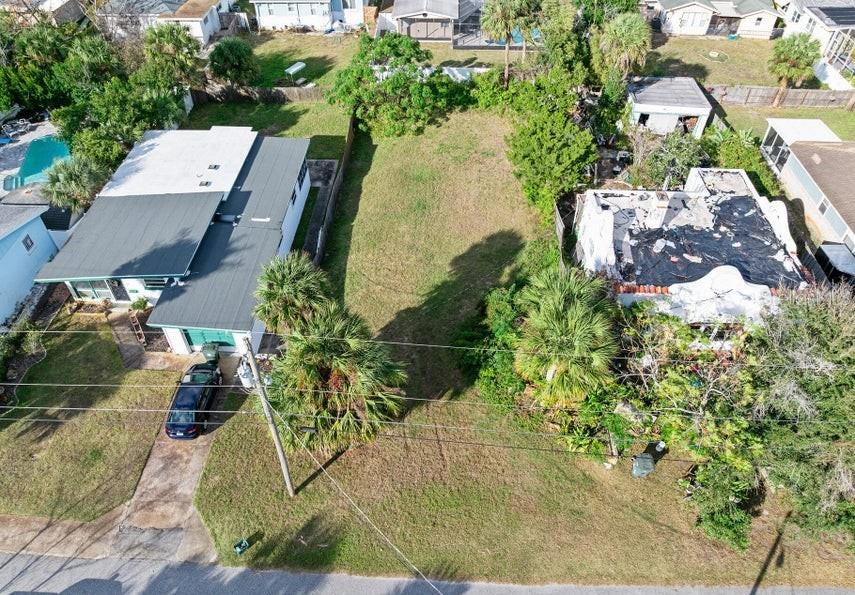 An aerial view shows a vacant lot situated between two residential houses — 339 MANHATTAN AVENUE, DAYTONA BEACH, FL