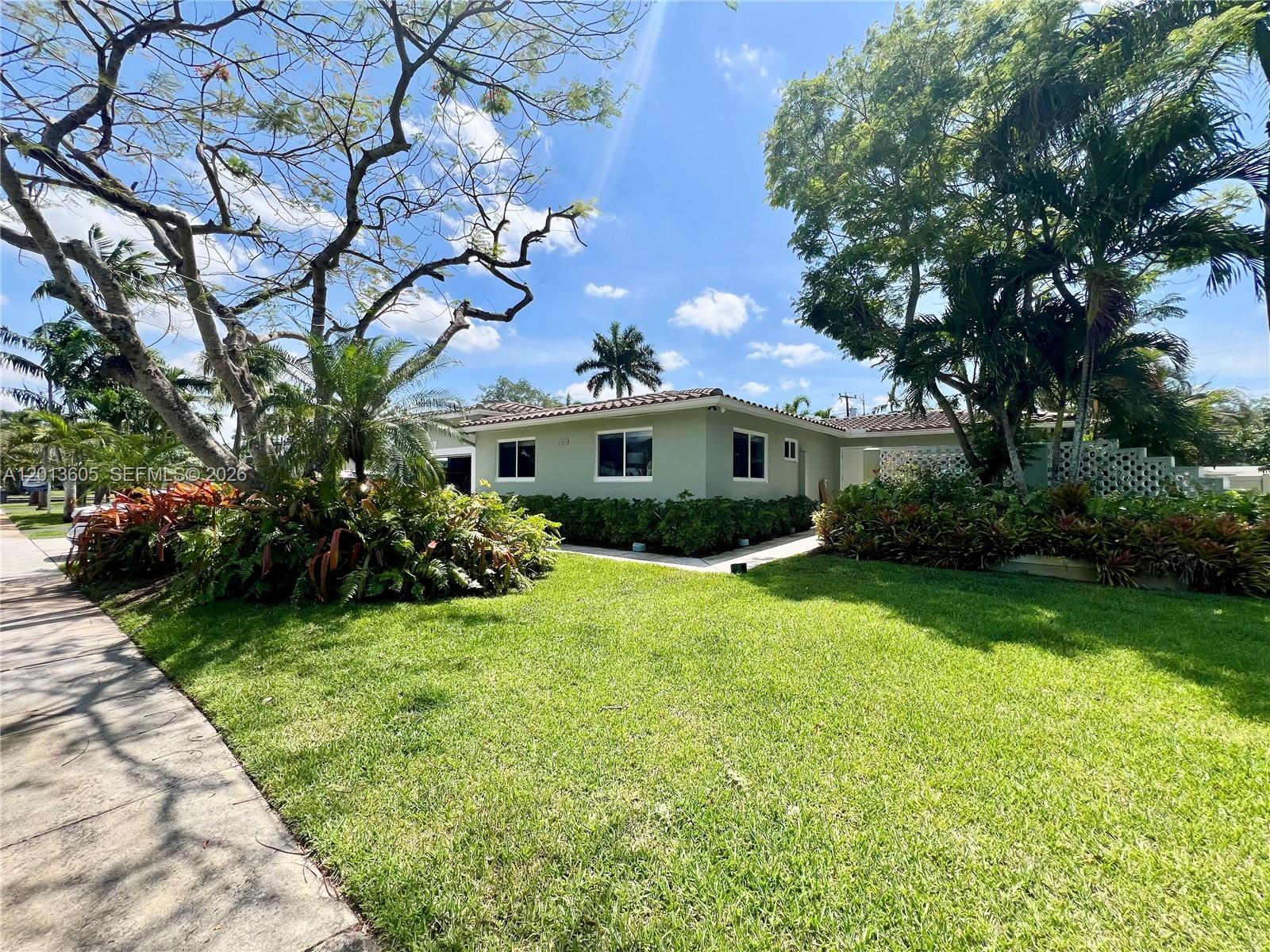 A light green single-story house sits on a grassy lawn surrounded by mature trees — 101 SW 58th Ave # 101, Plantation FL 33317, PLANTATION, FL