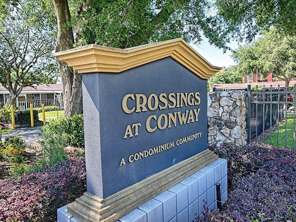 A stone-based monument sign identifies the Crossings at Conway condominium community — 4073 E MICHIGAN STREET UNIT 4073, ORLANDO, FL