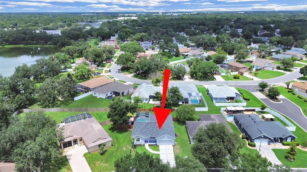 An aerial view shows a suburban house with a gray roof and a red arrow — 3313 MICHENER PLACE, PLANT CITY, FL
