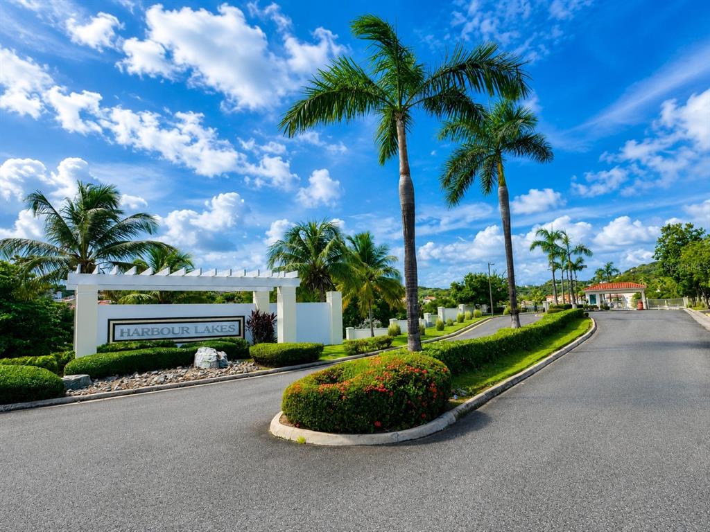 The entrance to the Harbour Lakes community features a white sign, palm trees, and landscaping — Palmas Drive COND. HARBOUR LAKES UNIT 26, HUMACAO, PR