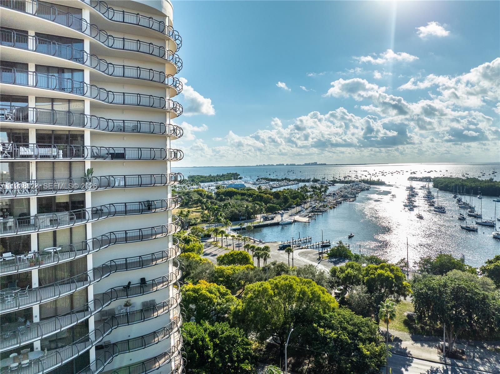 An exterior view of a high-rise apartment building overlooking a marina and the ocean — 2843 S Bayshore Dr # 6B, Miami FL 33133, MIAMI, FL