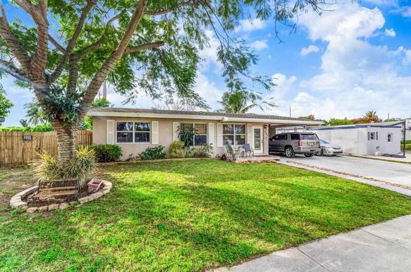 A single-story house with a large tree in the front yard and a driveway — 305 Henthorne Drive, Palm Springs FL 33461, PALM SPRINGS, FL