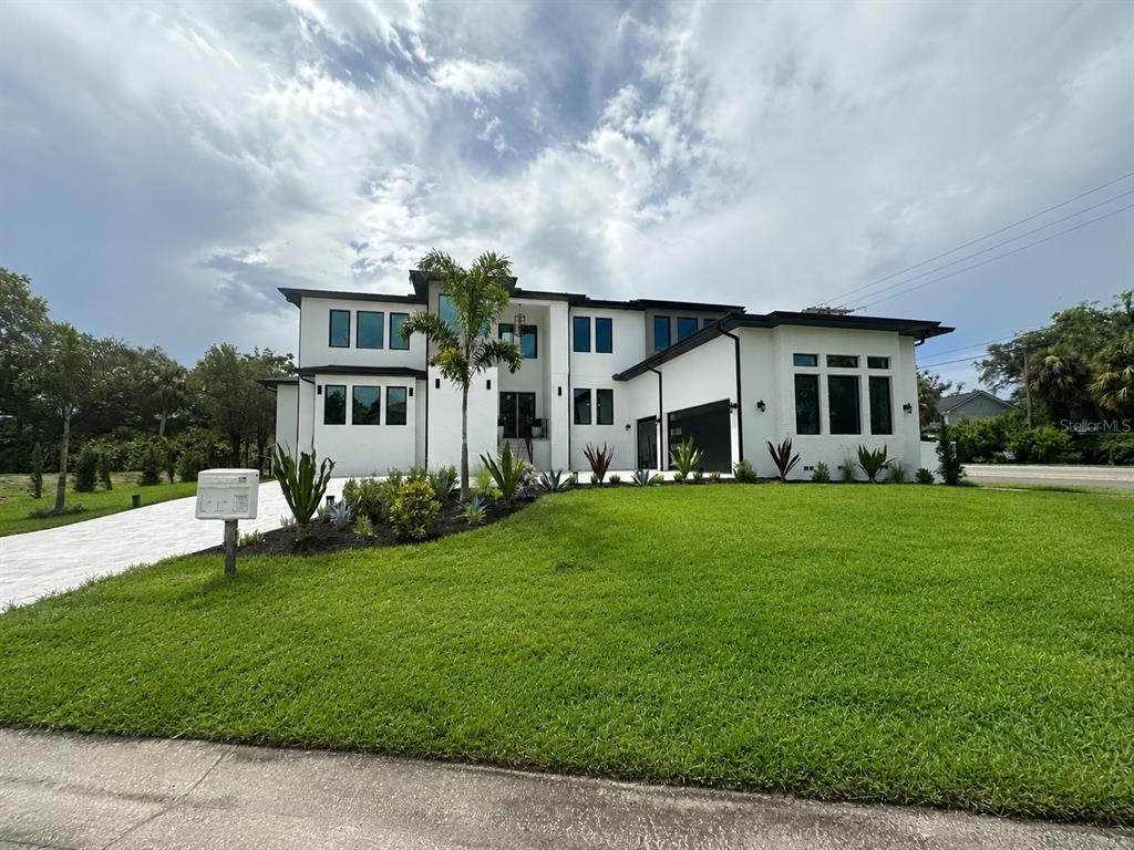 A modern two-story white house with black trim and a landscaped front lawn — 4706 W SAN CARLOS STREET, TAMPA, FL