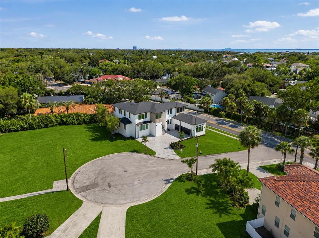 An aerial view shows a modern white house with a dark roof and a circular driveway — 4706 W SAN CARLOS STREET, TAMPA, FL