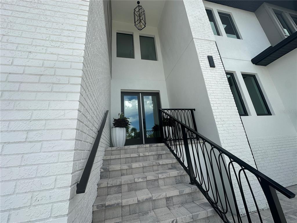 A set of stone stairs with black metal railings leads to a modern front entrance — 4706 W SAN CARLOS STREET, TAMPA, FL