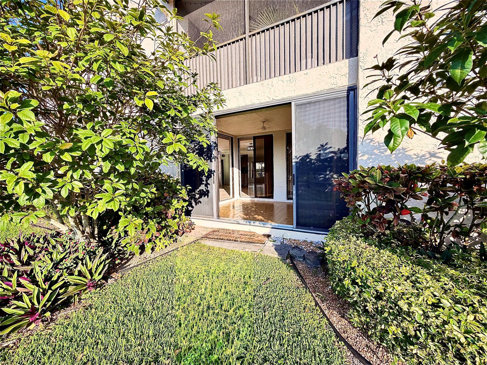 A ground-level patio with a sliding glass door leads into a tiled interior space — 8657 Boca Glades Boulevard W # C, Boca Raton FL 33434, BOCA RATON, FL