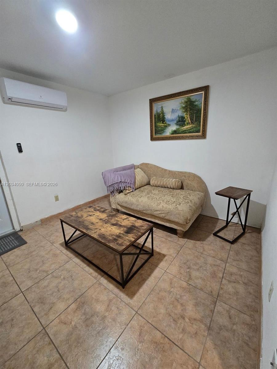 A small room features tile flooring, a beige chaise lounge, and a rustic coffee table — 4863 SW 148th Ct # 1, Miami FL 33185, MIAMI, FL